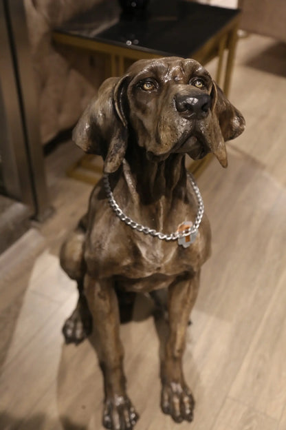 İç mekanda oturan, tasmalı bronz weimaraner köpek heykeli, detaylı tasarım