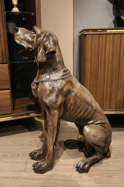 Oturmuş pozisyonda, detaylı dokulu Weimaraner köpek heykeli, iç mekanda dekoratif obje.